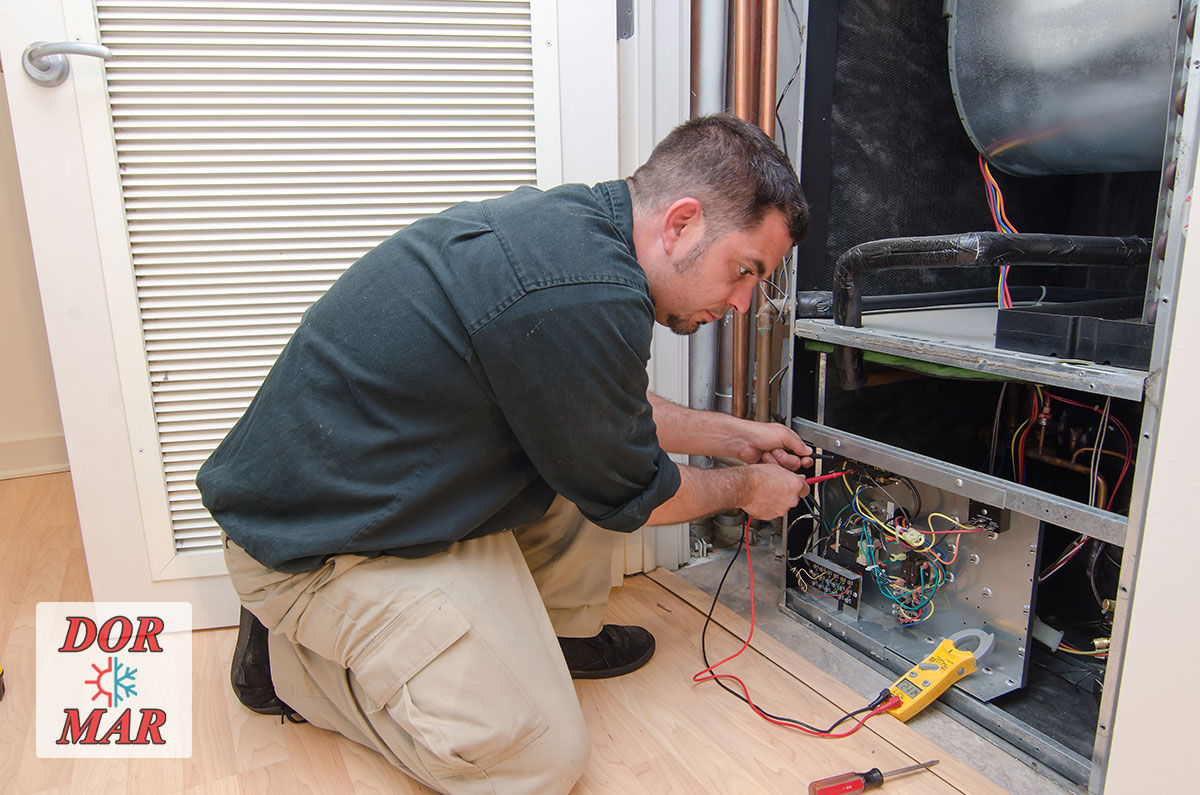 Dor-Mar HVAC technician performing a fall furnace tune-up in Columbus customer's home